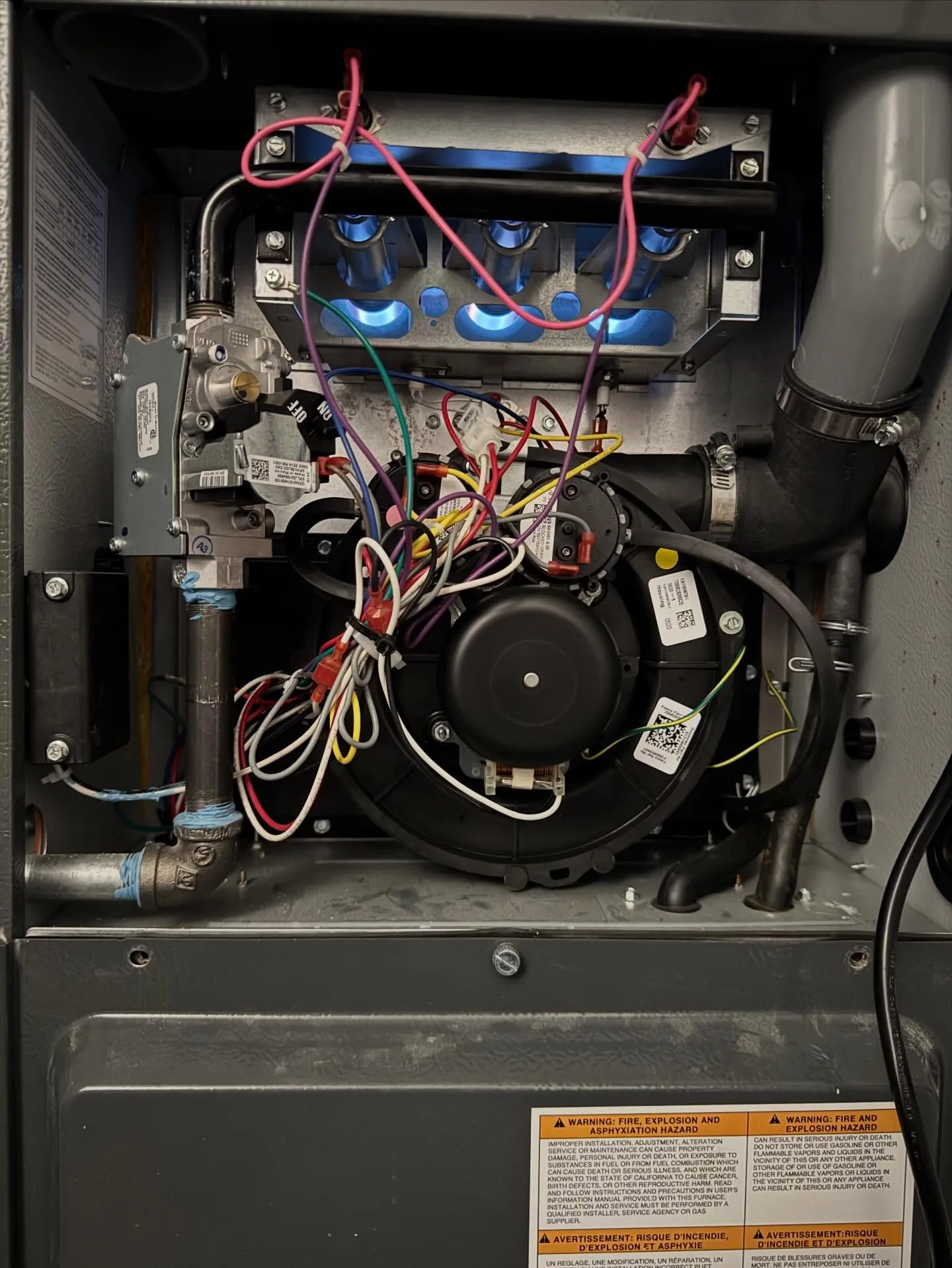 Lit blue burners inside a gas furnace during a repair in South Philadelphia